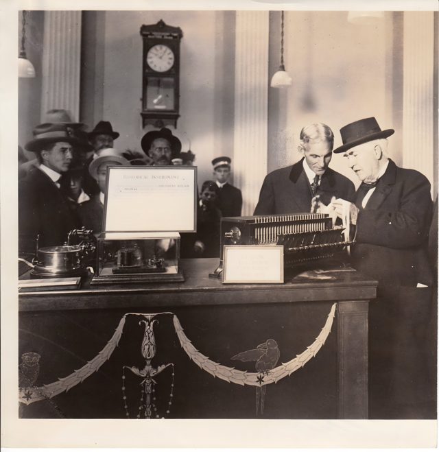 Thomas Edison and Henry Ford looking at Edison's telegraph perforator of 1871 to 1872