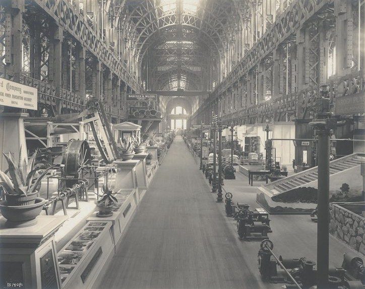 An aisle inside the Palace of Machinery, with the exposed timber trusses